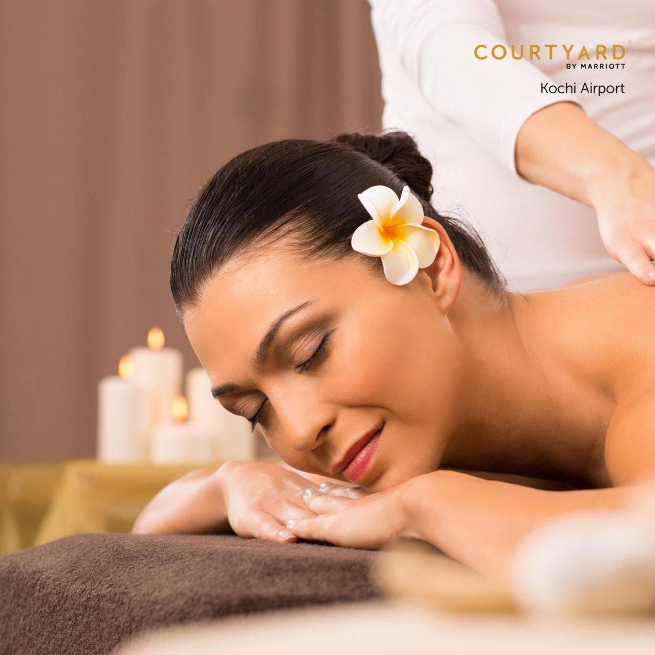 Courtyard By Marriott Kochi Airport Hotel Nedumbassery Eksteriør billede A woman receiving a massage